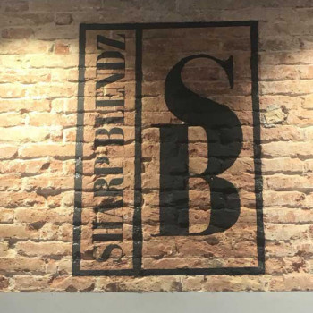 Logo y rotulación barberia Sharp Blendz sobre muro pintado por ArteExtra